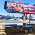 Mobile LED billboard trailer displaying a Caltex advertisement parked beside a road