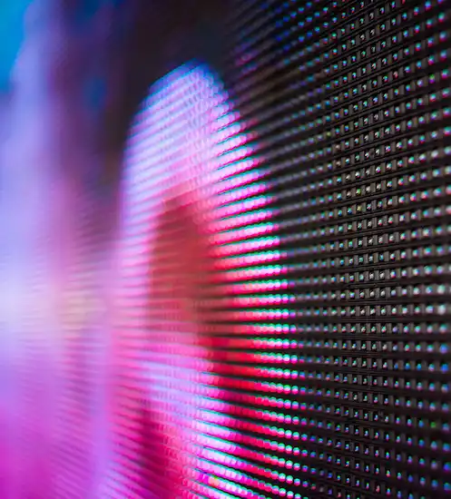 Close-up of a glowing LED display screen showing bright pink and magenta light with visible pixel dots